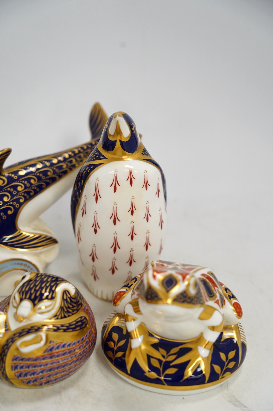 Eight Royal Crown Derby porcelain paperweights in the form of animals including a penguin, rabbit and seal, largest 17cm wide. Condition - seven good, one broken